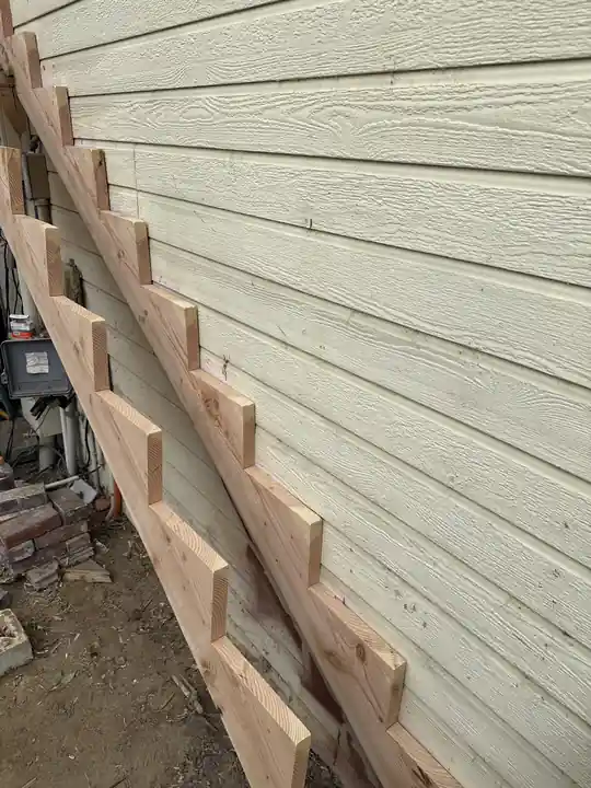 Deck ledger framing fastened against lap siding on a house wall