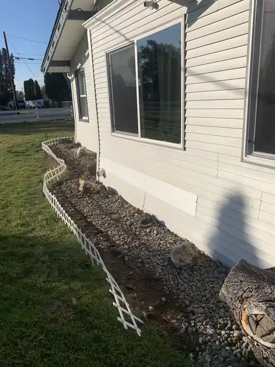 Vinyl siding repaired along a foundation bed at the base of a wall