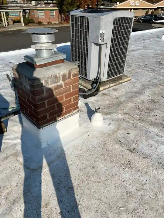 HVAC unit and brick chimney on the LabCorp roof during preparation