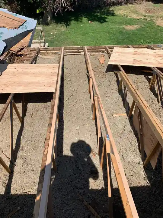 Damaged trusses and insulation exposed on a manufactured home roof